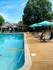 Charming outdoor pool area with vibrant umbrellas and lounge chairs, perfect for relaxation and leisure.