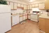 Charming kitchen with classic cabinetry, modern appliances, and inviting wood flooring, perfect for culinary enthusiasts.