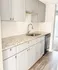 Sleek kitchen with modern gray cabinetry, elegant granite countertops, and stylish stainless-steel fixtures.