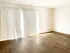 Bright, spacious living area with sleek hardwood floors and large sliding glass doors for abundant natural light.