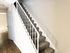 Elegant apartment interior showcasing a sleek staircase with modern railing and plush carpeting, complemented by warm hardwood floors.
