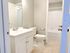 Bright and inviting bathroom with modern fixtures, featuring a sleek white vanity, full bathtub, and elegant tile flooring.