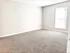Bright, spacious bedroom with plush carpeting and large window, perfect for serene living.
