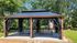 Charming outdoor gazebo with elegant black drapes, surrounded by lush greenery and a nearby playground slide.