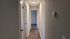 Inviting hallway with elegant flooring leading to bright, spacious rooms, offering a sleek and modern vibe.