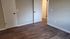 Bright room with elegant wood flooring and two modern white doors, perfect for customization and creating your dream space.