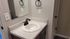 Elegant bathroom vanity with a sleek black faucet and pristine countertop, reflecting modern design.