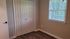 Charming bedroom with sleek hardwood floors, ample closet space, and a sunlit window with garden views.