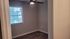 Inviting room with elegant hardwood flooring, a large window for natural light, and a modern ceiling fan.