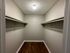 Spacious walk-in closet with elegant hardwood flooring and ample shelving, perfect for organized storage.
