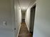 Inviting hallway with elegant wood flooring and modern recessed lighting, leading to spacious rooms.