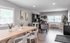 Bright and modern open-concept dining and living space featuring stylish decor, wooden dining table, and abundant natural light.