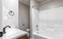 Bright and modern bathroom featuring a sleek white bathtub, elegant sink, and contemporary fixtures.