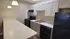 Modern kitchen with sleek black appliances, white cabinetry, and elegant marble countertops offering a stylish cooking space.