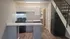 Charming apartment kitchen with modern cabinetry, sleek appliances, and cozy staircase, perfect for urban living.