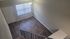 Charming entryway with sleek hardwood floors and modern staircase, flooded with natural light.