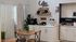 Charming apartment kitchenette with elegant coffee bar, cozy wooden dining set, and modern cabinetry.