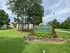 Charming entrance to Pine Ridge Apartments with lush greenery and welcoming signage.