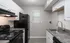Modern kitchen with sleek appliances, elegant white cabinetry, and a stylish granite countertop.
