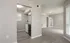 Modern open-concept apartment with sleek laminate flooring, bright living area, and a compact kitchen featuring stainless steel appliances.