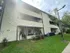 Charming two-story apartment building with lush greenery, covered balconies, and modern exterior design.