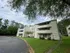 Charming apartment complex nestled in a serene, tree-lined setting with modern architectural design and lush green surroundings.