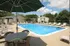 Inviting outdoor pool area with comfortable lounge chairs and shaded tables, perfect for relaxation and summer fun.