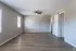 Spacious, sunlit room with elegant wood flooring and modern ceiling fan, perfect for a cozy living area.