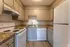Charming kitchen boasting granite countertops, sleek cabinetry, and modern appliances in a cozy apartment setting.