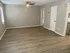 Bright and spacious living room with modern wood flooring, neutral tones, and a ceiling fan. Perfect for comfortable living and stylish decor opportunities.