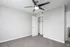 Bright, modern bedroom with plush carpet, ceiling fan, and spacious closet space.