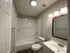 Modern bathroom with elegant lighting, sleek fixtures, and a pristine bathtub for a refreshing experience.
