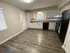 Modern kitchen with sleek cabinets, stainless steel appliances, and elegant wood flooring offers a bright and inviting space.