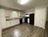 Modern kitchen with sleek white cabinetry, elegant countertops, and stainless steel appliances, complemented by warm wooden flooring.