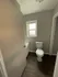 Cozy bathroom featuring elegant dark wood flooring, natural light from a window, and modern fixtures.