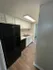 Sleek modern kitchen with stylish black appliances, elegant white cabinetry, and warm wood flooring, perfect for culinary creativity.