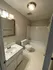 Bright and modern bathroom with sleek vanity, polished fixtures, and a spacious bathtub and shower.