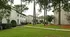 Charming apartment complex with lush green lawns, mature trees, and inviting brick buildings offering serene living.