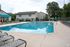 Inviting outdoor swimming pool area with lounge chairs, surrounded by lush greenery, offering a serene retreat.
