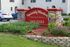 Inviting entrance to Spanish Mission Apartment Homes with vibrant landscaping and stone signage.
