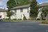 Charming brick apartment exterior with manicured landscaping and lush greenery, offering serene suburban living.