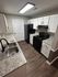 Modern kitchen with elegant granite countertops, sleek black appliances, and warm wood flooring.