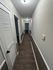 Sleek hallway with elegant hardwood flooring and modern lighting, leading to multiple rooms.