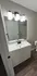 Sleek contemporary bathroom with elegant lighting, stylish vanity, and modern fixtures offering a serene atmosphere.