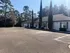 Charming residential building surrounded by lush trees, offering a serene and inviting atmosphere with spacious parking.