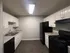 Modern kitchen with sleek black appliances, ample white cabinetry, and elegant countertops.