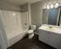 Modern bathroom with elegant bathtub, sleek vanity, and stylish lighting, perfect for relaxation.