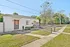 Charming brick cottage with a welcoming entrance, surrounded by lush greenery and set in a serene neighborhood.