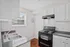 Bright and inviting kitchen with modern black appliances, sleek countertops, and white cabinetry in a cozy apartment.