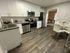 Modern kitchen with elegant white cabinetry, stainless steel appliances, and chic dining area, perfect for culinary creativity.